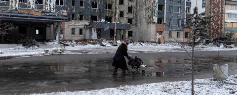 FILE PHOTO: A woman walks past a building damaged by a Russian military strike, amid Russia's attack on Ukraine, in the town of Pokrovsk in Donetsk region, Ukraine December 12, 2024. REUTERS/Inna Varenytsia/File Photo ORG XMIT: FW1