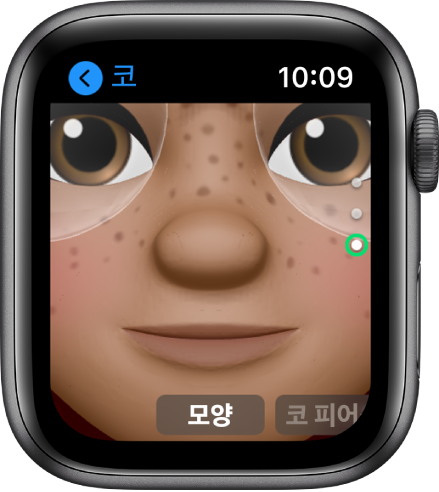 코 편집 화면을 보여주는 Apple Watch의 미모티콘 앱. 코에 초점을 맞추어 얼굴을 클로즈업함. 아래에 모양이라는 단어가 나타남.