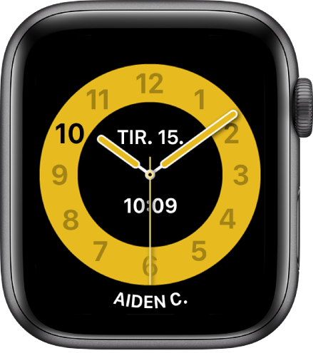 Skoletid-urskiven som viser en analog klokke med dato og digitalt klokkeslett ved midten. Nederst er navnet på personen som bruker klokken.
