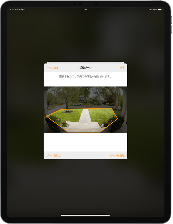 iPadの画面。ドアベルのカメラで撮影された画像内の活動ゾーンが表示されています。この活動ゾーンは玄関先と通路を網羅していますが、車道と私道は除外されています。画像の上には「キャンセル」ボタンと「完了」ボタンがあります。下には「ゾーンを追加」ボタンと「ゾーンを反転」ボタンがあります。