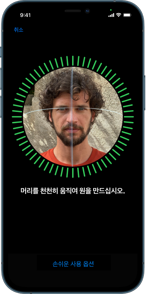 Face ID 인식 설정 화면. 원형 프레임 안에 얼굴이 있는 화면이 표시됨. 아래에는 사용자에게 천천히 머리를 움직여 원을 완성하라는 지침이 표시된 텍스트가 있음. 화면 하단 근처에 손쉬운 사용 옵션 버튼이 표시됨.