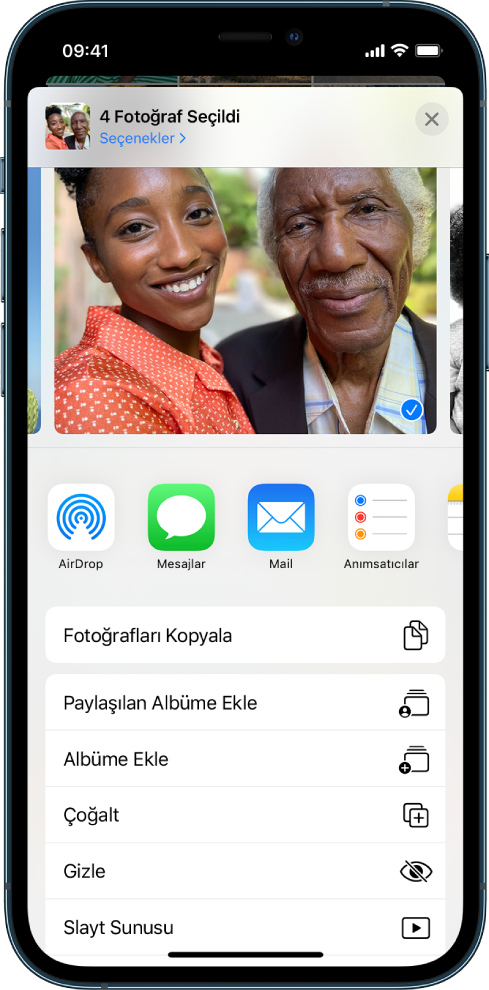 Fotoğraflar paylaşım ekranı. Seçilen fotoğraf ekranın üst kısmında. Fotoğrafın altında paylaşma seçenekleri vardır. Paylaşma seçeneklerinin altında eylemler listesi olup üstten alta doğru şunlar vardır: Fotoğrafları Kopyala, Paylaşılan Albüme Ekle, Albüme Ekle, Çoğalt, Gizle ve Slayt Sunusu.