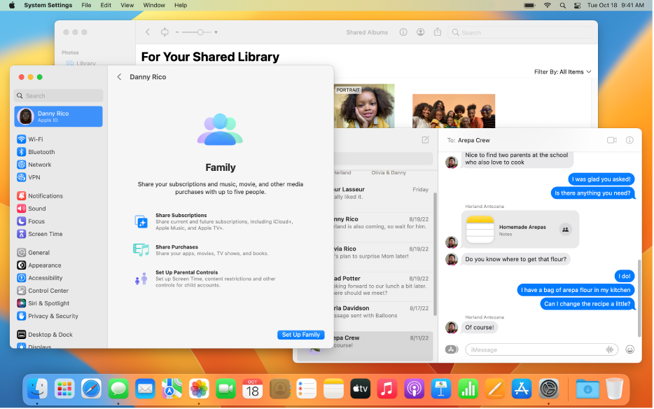 Mesa do Mac com várias janelas abertas: Ajustes do Sistema mostra os ajustes de Compartilhamento Familiar, Fotos mostra uma Fototeca Compartilhada do iCloud, e a janela do app Mensagens mostra uma conversa que inclui uma nota em que um grupo está colaborando.