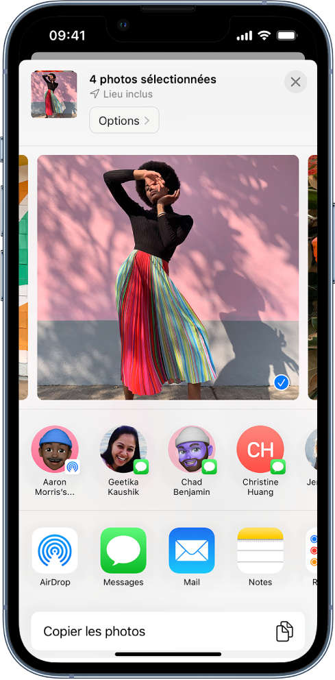 L’écran de partage avec une photo sélectionnée en haut, comme indiqué par la coche blanche dans un rond bleu. La ligne située sous la photo suggère des contacts avec qui partager cette dernière. D’autres options de partage sont proposées en dessous, notamment, de gauche à droite : AirDrop, Messages, Mail et Notes. En bas de l’écran se trouve le bouton « Copier les photos ».