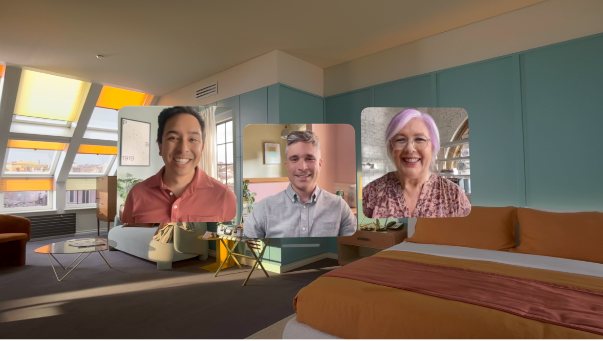 A FaceTime call on Apple Vision Pro, showing three tiles from other participants overlaying the user’s room.