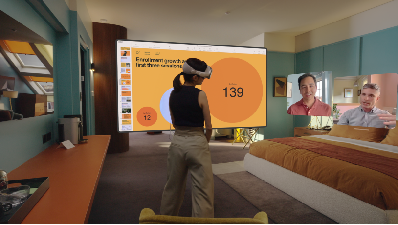 Une personne portant l’Apple Vision Pro pendant un appel FaceTime. Les vignettes des autres participants à l’appel sont visibles en regard d’un écran partagé.