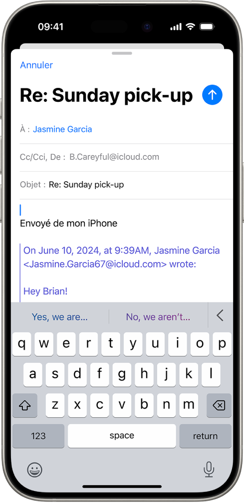 iPhone affichant un e-mail avec une réponse en cours. Des suggestions de réponse apparaissent en haut du clavier.