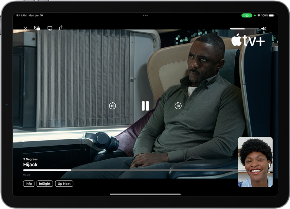 Hovor FaceTime, ve kterém se zobrazuje relace SharePlay se sdíleným videem z Apple TV+. V malém okénku se zobrazuje tvář účastníka, který video sdílí, a zbytek obrazovky vyplňuje samotné sdílené video, překryté ovládacími prvky přehrávání.