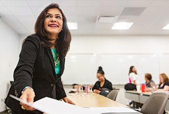 An HR representative smiling while handing out an information document