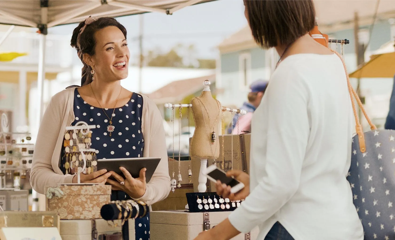 A woman customer talking to a vendor at an outdoor market