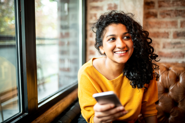 Woman holding her phone looking to the left