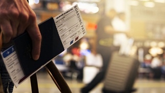  Flugticket mit Flughafen im Hintergrund