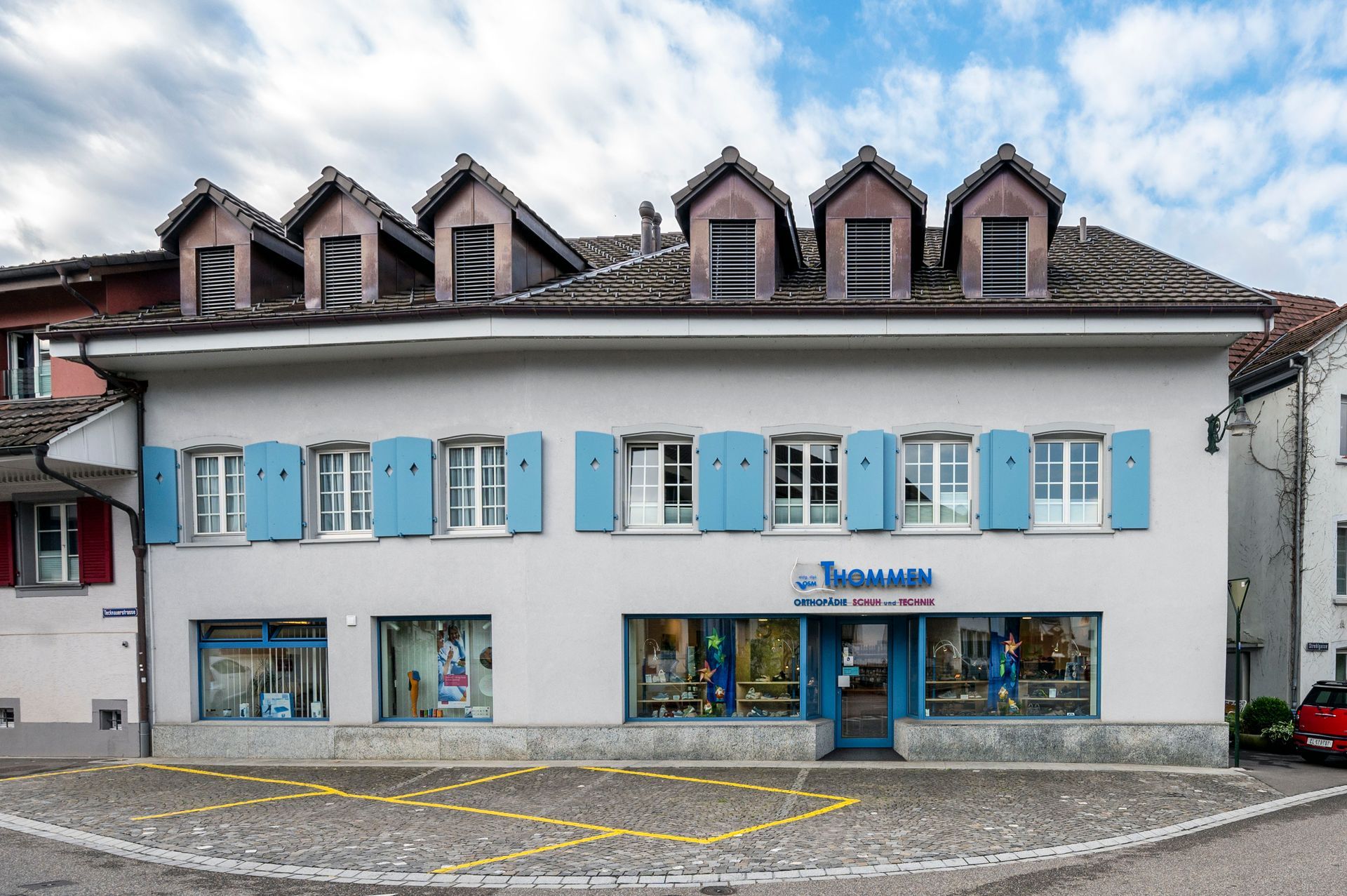 Ein großes weißes Gebäude mit blauen Fensterläden