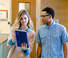 Two people look at a tablet computer.