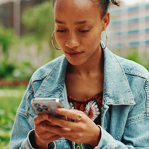 Image of women reading a text from a scammer impersonating the UPS.