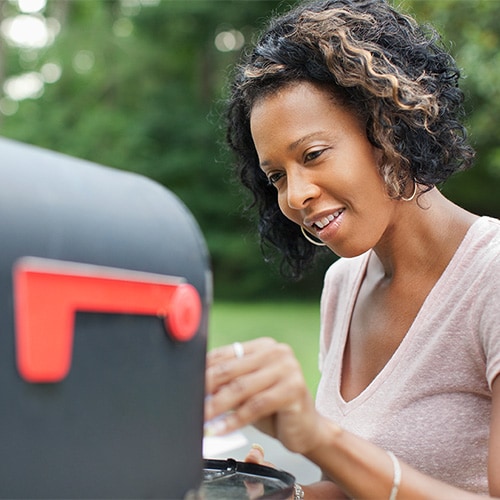 An image of a person mailing a letter at a secure location to help stop scammers from intercepting it.