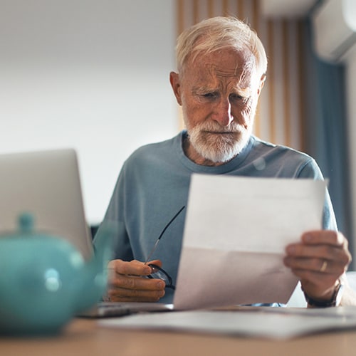 Man sitting a table reading a paper