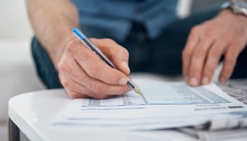 Hand holding pen reviewing paper