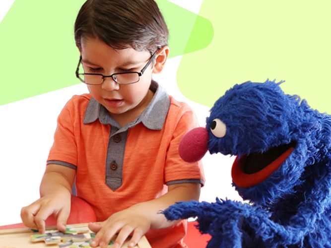 Grover and a child doing a puzzle.