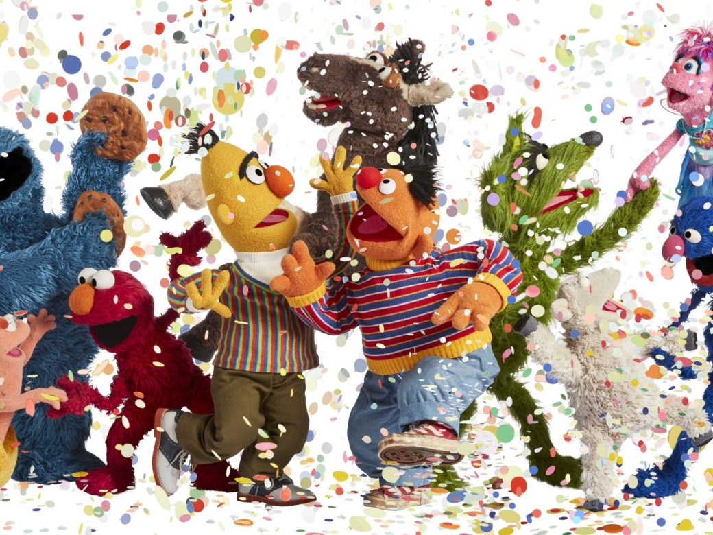 Several Muppets dance and party while confetti falls on them.