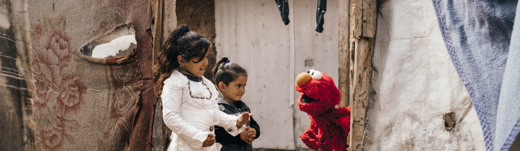 Elmo talking to two children.