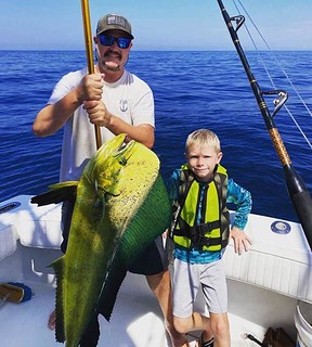 Photo of father and son holding large dolphin-fish