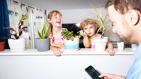 two young girls smiling next to plants