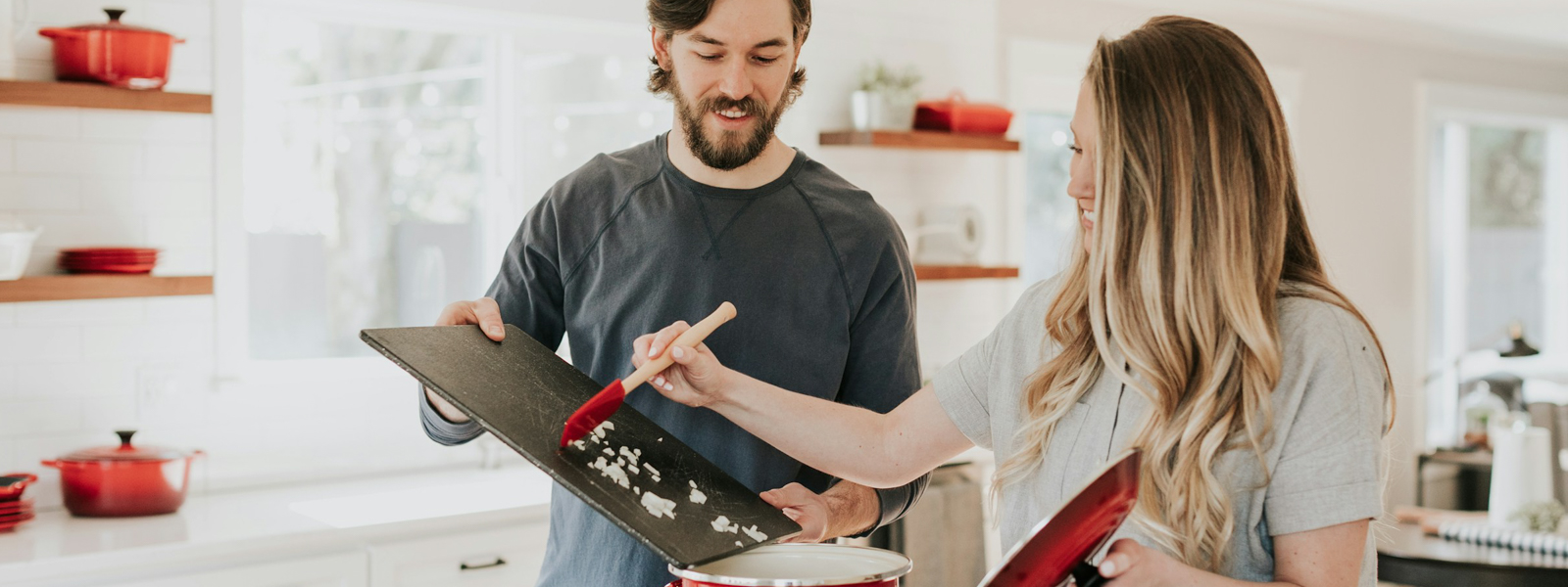 Man and woman cooking together over a stove