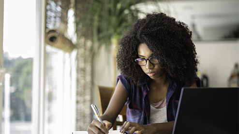 Teenaged girl studying at home