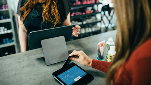 Woman making a purchase at a store with her credit care