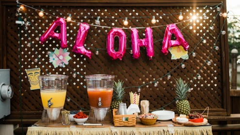 Festive table with “Aloha” balloons in the background