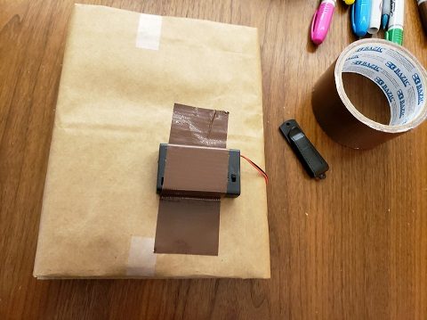 The battery pack taped to the back of the book