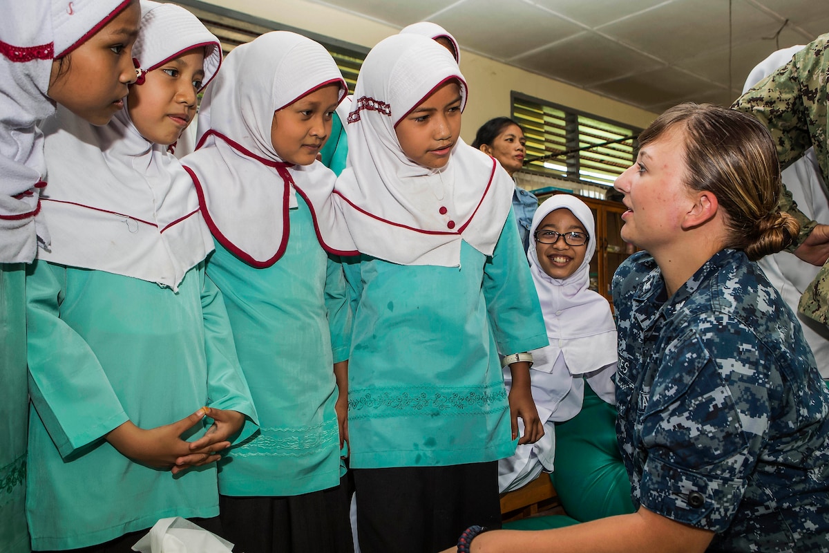 Navy Petty Officer 3rd Class Emily Cates talks with students.