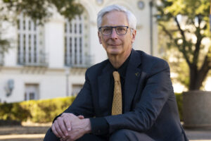 Art Markman sits outside on campus in a suit