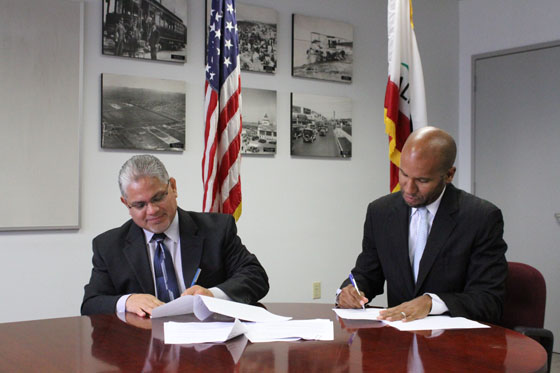 U.S. Department of Labor Regional Administrator for the Western Region Ruben Rosalez and California Department of Justice General Counsel Brian Nelson sign the memorandum of understanding.