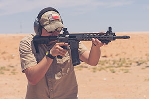 Man Shooting Rifle in the Desert