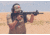 Man Shooting Rifle in Desert