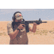 Man Shooting Rifle in Desert