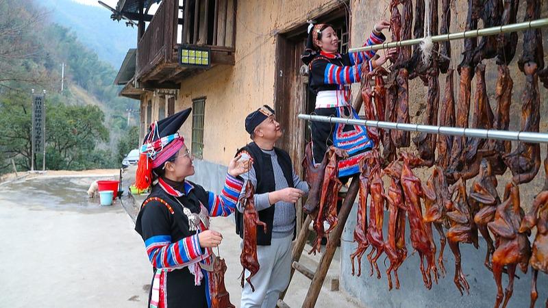 Yao people prepare traditional delicacy for Spring Festival