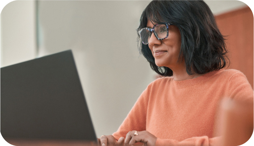 A business woman typing on a laptop at a table