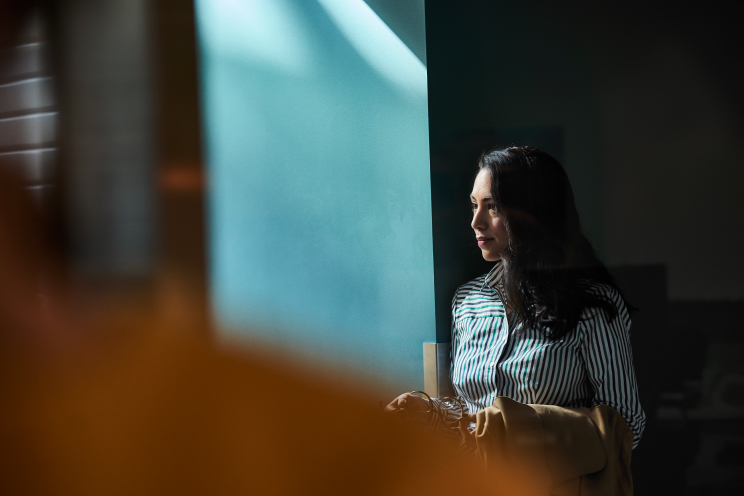 A person standing by a doorway looking outside