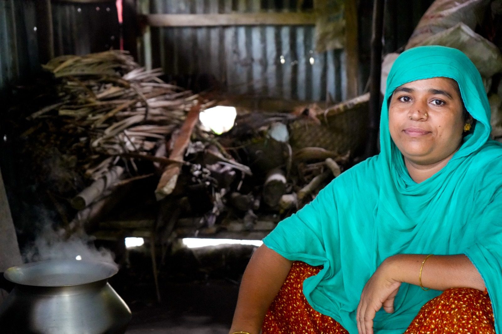 Sahanur cooks in her damaged kitchen.