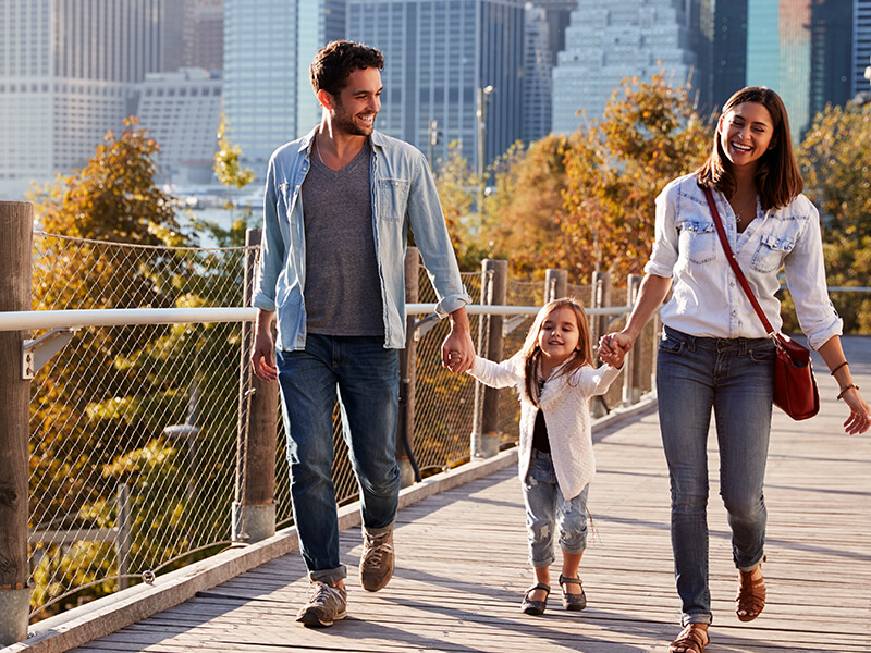 papa, niño y mama caminando a lado de la cuidad