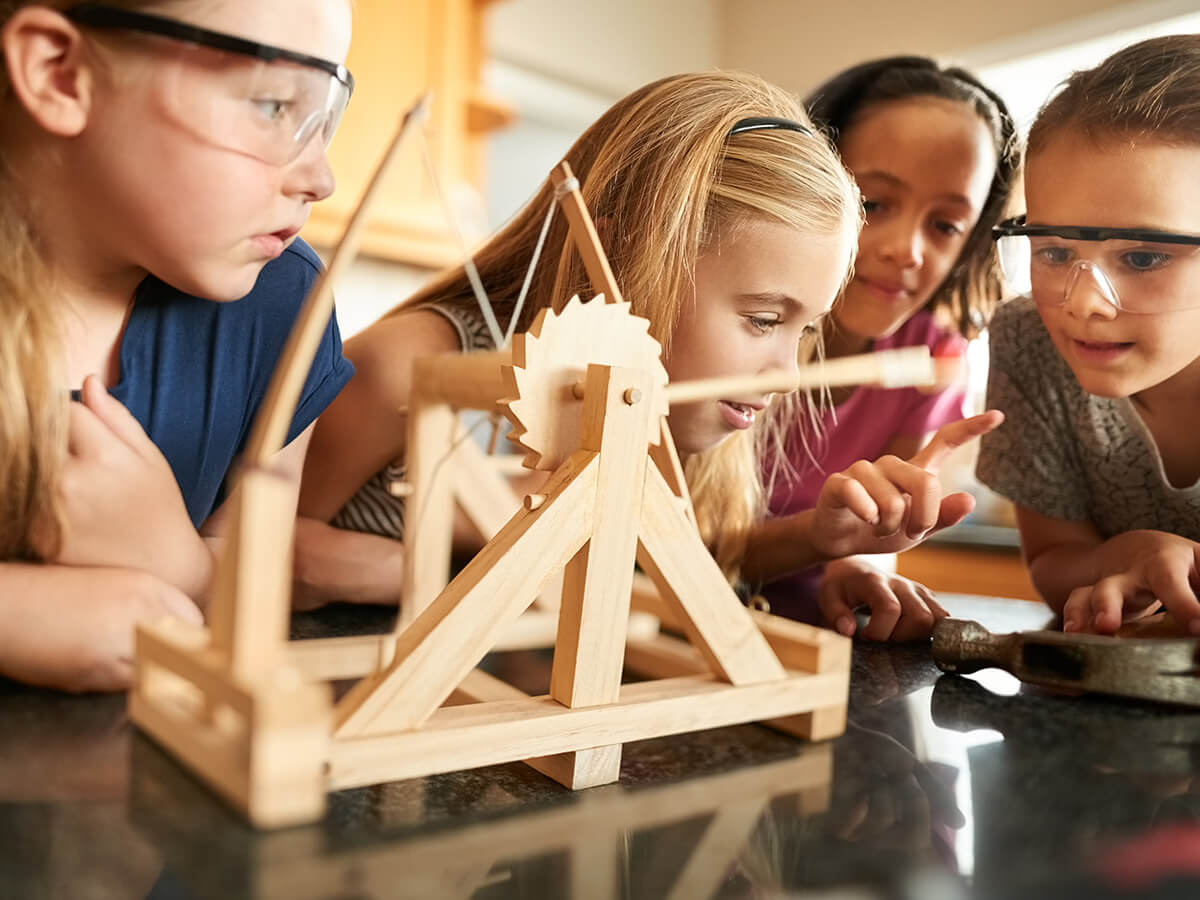 Niños jugando con una catapulta