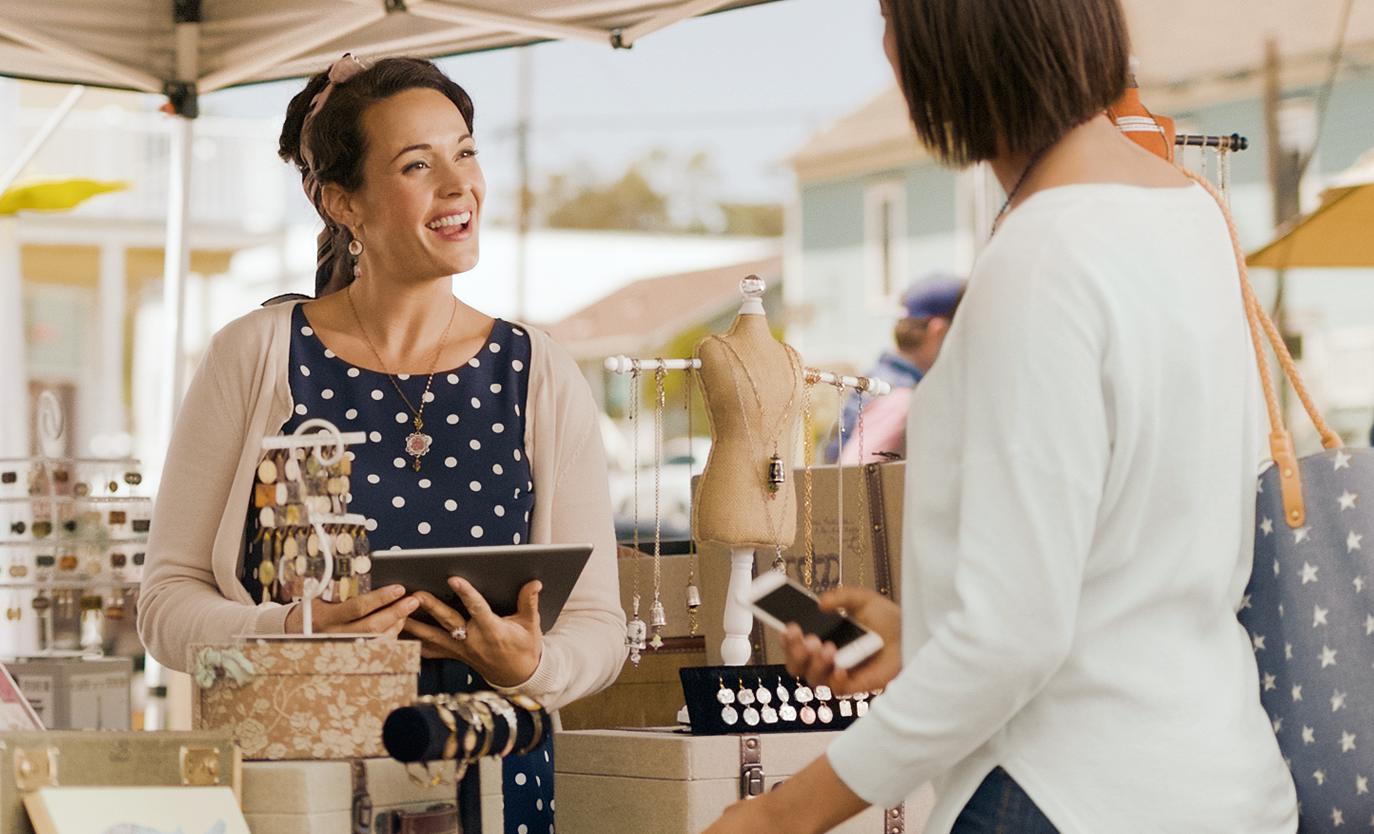 Une femme conversant avec un commerçant dans un marché extérieur