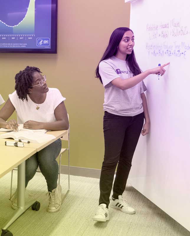 Students writing on a white board