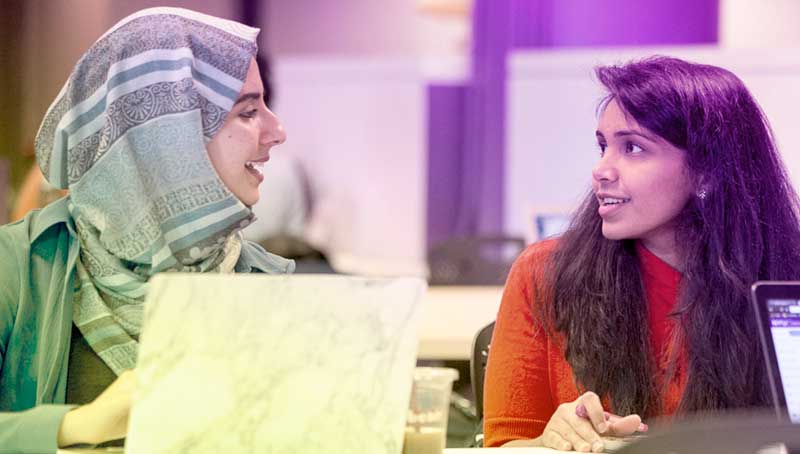 Students sitting at a desk talking