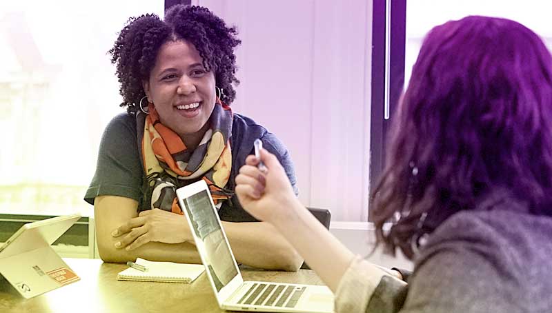 Students and faculty discussing at a table