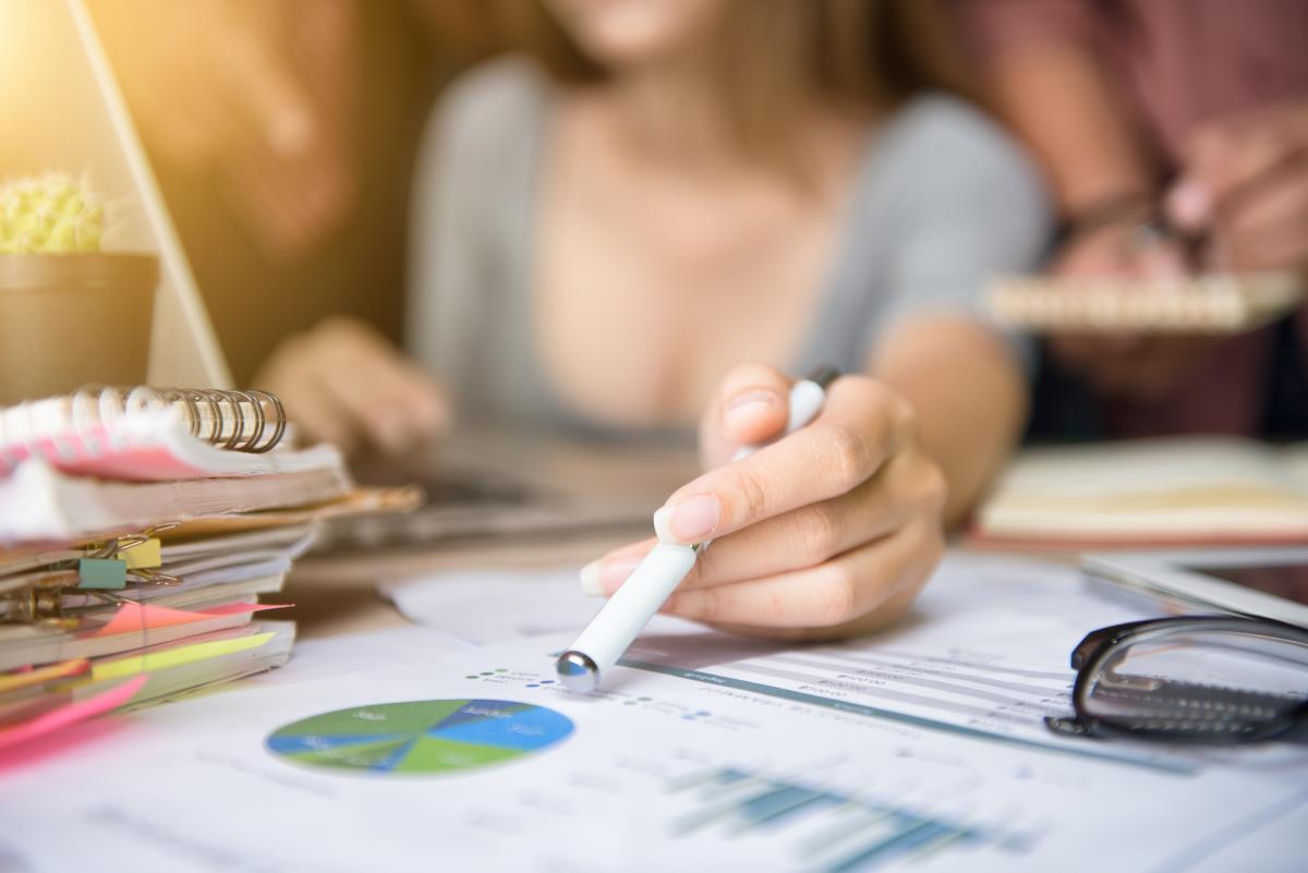 Woman's hands demonstrate pie chart on financial planning documents