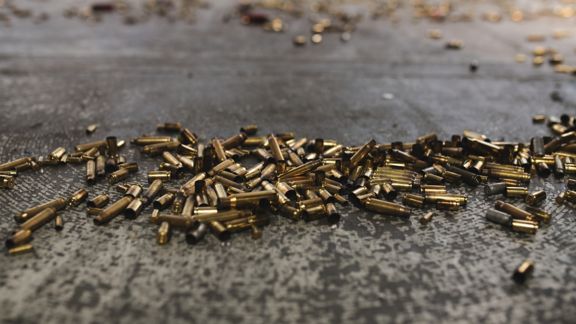 Close up of spent gun casings on the ground